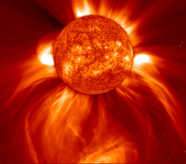 Large, eruptive prominence in He II at 304, with an image of the Earth added for size comparison. This prominence from 24 July 1999 is particularly large and looping, extending over 35 Earths out from the Sun. Erupting prominences (when Earthward directed) can affect communications, navigation systems, even power grids, while also producing auroras visible in the night skies. 